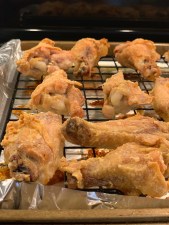 Baked, lightly golden chicken wings on a wire rack over a foil-lined pan