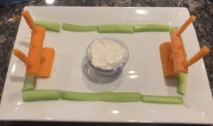 Veggie football field platter with carrot goal posts, celery sidelines and dip